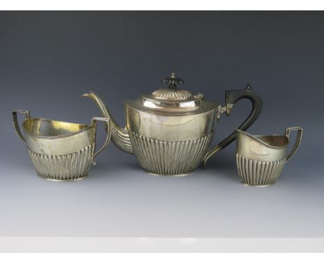 A George V silver three-piece tea service, maker Barker Brothers, Chester, 1914, of oval outline with half reeded decoration,