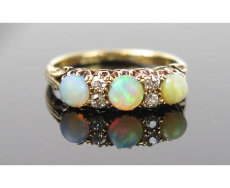 An Opal, Diamond and 18ct Gold Ring, central stone green and red, 4mm approximately, flanked by 4 diamonds and a further two 