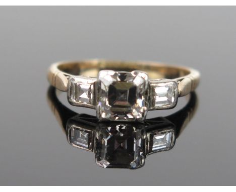 An Art Deco Diamond Three Stone Ring, central stone 6x5.5mm approximately, flanked by two smaller, in a platinum geometric cl