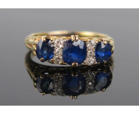 A Sapphire, Diamond and 18ct Gold Ring, the central circular stone c. 5.7x5mm, flanked by six small diamonds and two smaller 