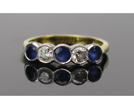 Sapphire and Diamond Five Stone Ring in an 18ct hallmarked rub over setting, c. 3.8mm stones, 19mm head, size O.5, 3.7g 