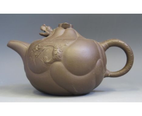 A Chinese Yixing pottery teapot, of squat circular form, decorated with dragons amongst clouds, the lid with nodding dragons 