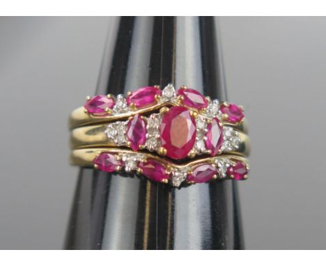 A Modern Ruby, Diamond and Gold Trio/Trinity Ring, the central ring with oval stone 6x4.2mm, flanked by two shaped ring, ring