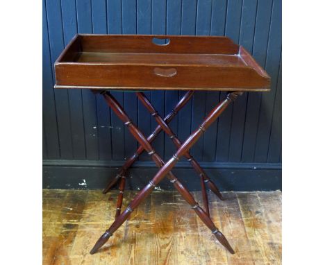 A 19th century mahogany butlers tray of rectangular outline with solid sides, together with a folding stand with ring turned 
