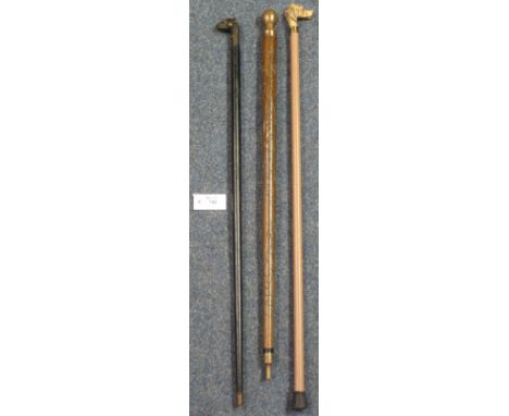 Two dog's head handled walking sticks and a brass mounted, carved, wooden walking stick/snooker cue. (3)
