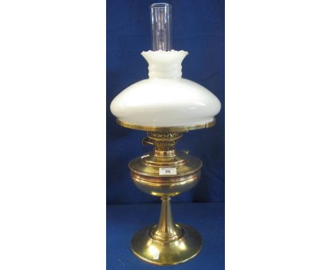 Brass double burner oil lamp with brass pedestal reservoir and white glass shade and clear chimney.