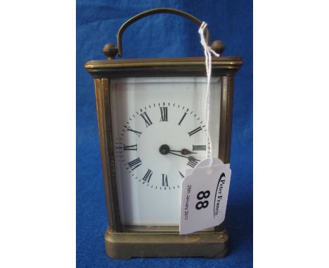Small French brass carriage clock with full depth Roman numeral enamel face, includes key.