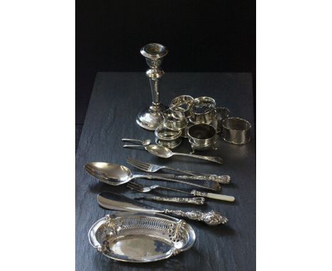 A collection of silver items including 7 napkin rings, single weighted candlestick, pierced dish and various other items 