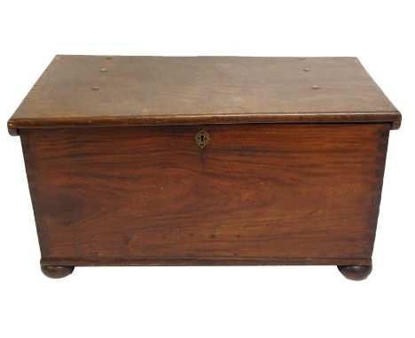 A Colonial oak trunk the hinged top above wrought steel bail handles and on bun feet, 119cm wide x 60cm deep x 61cm high