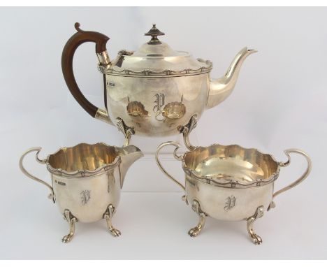 A three piece silver tea service by Cooper Brothers & Sons, Sheffield 1931, of globular shape with scalloped border on four o