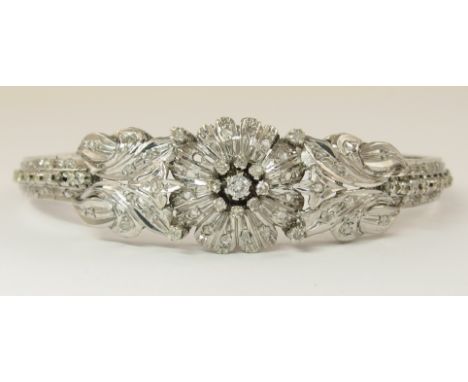 An 18ct white gold diamond set Lebanese floral bracelet deeply engraved leaf and flower motifs are set with a mixture of bril