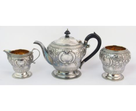 A Bachelor's three piece silver tea service by George Howson, Sheffield 1906, of squat baluster form with foliate embossing, 