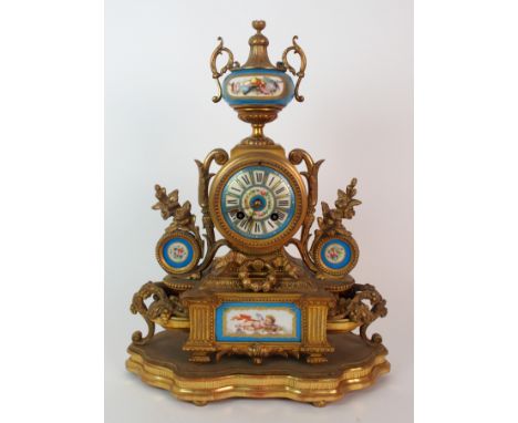 A French Sevres-style painted porcelain and gilt metal mantle clock clock dial surmounted with gilt metal mounted urn with po