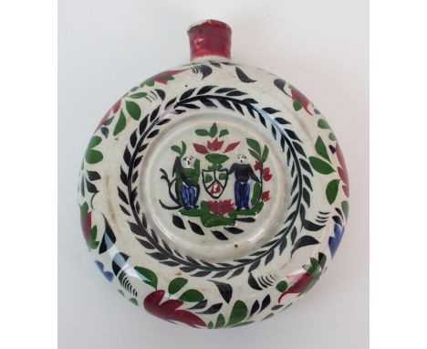 A Portobello Pottery painted flask of circular-form with inset image of two men centred by a shield, red and blue flowers to 