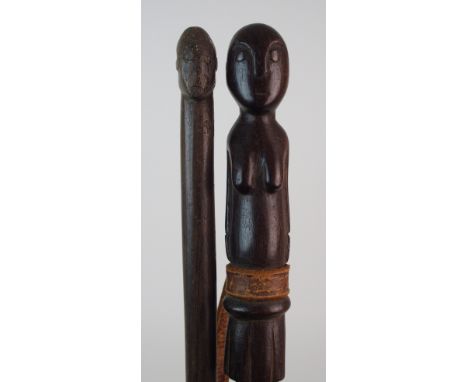 An African carved wood walking stick with a naked female figure, 89cm long and another with a crudely carved head, 87cm long 