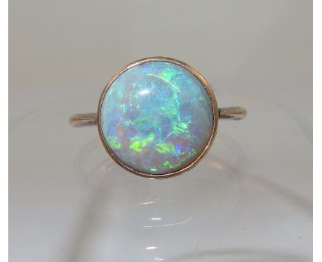 A Black opal cabouchon in a 9ct rose gold vintage ring mount with pretty floral and wreath engraving to the bezel, the opal h