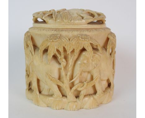 An African ivory tusk box and cover carved with a procession of elephants amongst trees, 12.5cm high