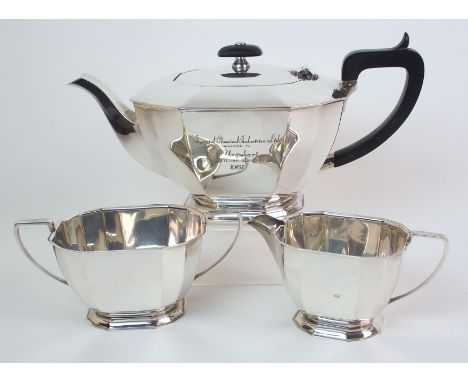 A three piece silver tea service by Cooper Brothers & Sons, Sheffield 1967 of faceted rectangular form on matching stepped ba