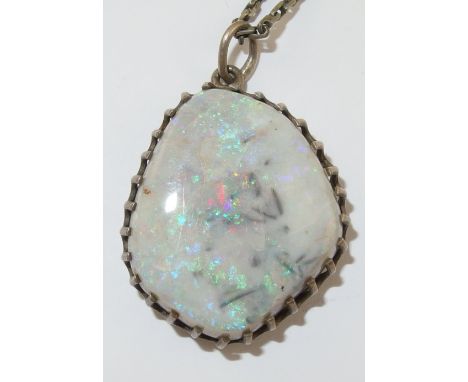 A boulder opal pendant with a white/grey matrix with flashes of purple/red and green, set into a white metal asymmetrical gal