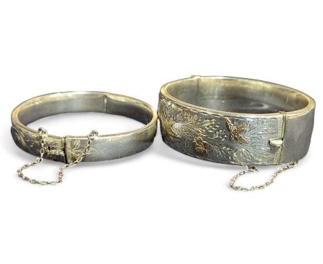 A silver hinged bangle, with half engraved decoration and gold accents, Chester, Smith & Pepper Ltd, 1959; together with a sl