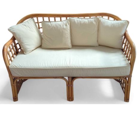 A bamboo framed two-seater sofa, with cream upholstered cushions, 120cm, 55cm, 75cm