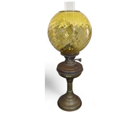 An oil lamp with amber glass shade, brass reservoir and base, 58cms high