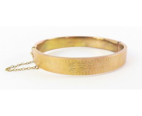 A 9ct gold hinged bangle, with half engine turned decoration, Chester HM, 5.5cm internal diameter, 11.1g gross