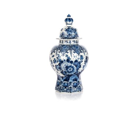 A DUTCH DELFT BLUE AND WHITE URN AND COVER, 1884 the fluted baluster body hand painted in cobalt blue with a central peacock 