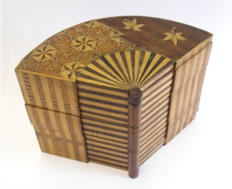 A Japanese marquetry fan-shaped trinket box the top richly decorated in various woods with star, striped and leaf motifs, wit
