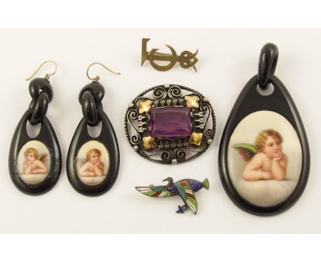 A yellow and white metal Arts & Crafts brooch, an Egyptian revival enamelled brooch, and a ceramic plaque pendant and earring