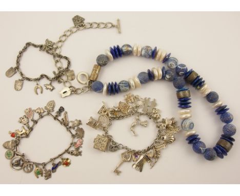 A lapis lazuli and pearl statement necklace, three silver and white metal charm bracelets and a costume jewellery example