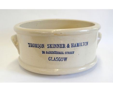 A large circular salt-glazed stoneware chemist's circular crock with two handles and sat upon three ball feet and with blue g
