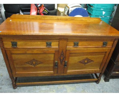 Edwardian light oak sideboard with extended back, cutlery drawer and one short drawer, over twin cupboard doors, on turned le