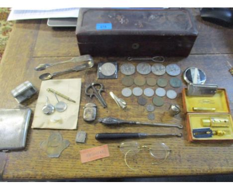 A Japanese lacquered glove box containing various coins, silver sugar tongs, vesta case, and French souvenir case containing 