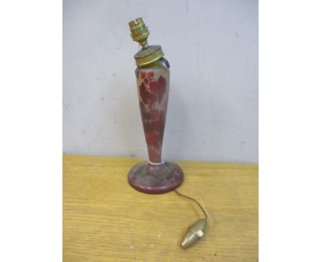 A cameo brown/red opaque glass lamp base decorated with vines, leaves and flowers, on splayed foot with a cut out notch, sign