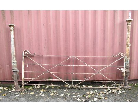 A 19th century white painted iron estate gate of strap and bar construction with a curved latch and scrolled ends, and a pair