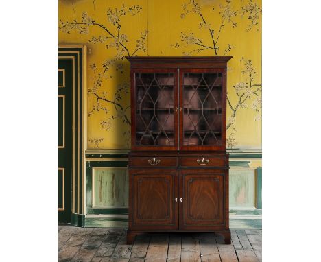 A 19TH CENTURY MAHOGANY BOOKCASE, with outset cornice above twin glazed doors enclosing a shelved interior, above a frieze of