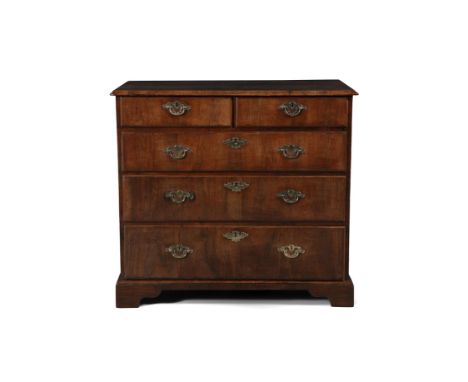 A GEORGE II WALNUT CHEST OF DRAWERS, the rectangular quarter veneered top above two short and three long drawers, with brass 