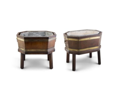 A PAIR OF MAHOGANY AND BRASS BOUND OCTAGONAL CELLARETTESwith ring turned handles, with zinc liners, on panelled square suppor