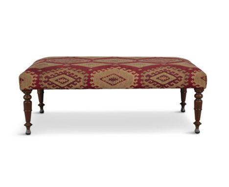A VICTORIAN MAHOGANY FRAMED UPHOLSTERED STOOL of oblong shape, covered in an Aztec patterned fabric, on turned tapering legs.