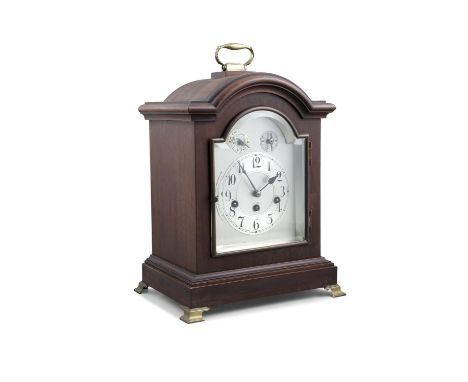 A STAINED WOOD CASED MANTLE CLOCK, in the Georgian taste, with silvered dial and chiming movement, raised on brass bracket fe