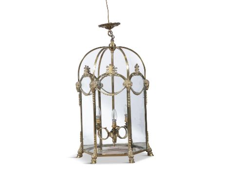 A LARGE EDWARDIAN BRASS FRAMED HEXAGONAL HALL LANTERN,with leaf cast coronas and chain, arched supports and six glass panel s