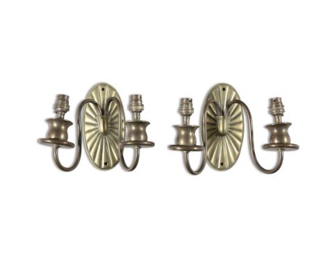 A PAIR OF BRASS TWIN LIGHT WALL SCONCES, C.1920 each with oval paterae back plate and scroll arm branches, with upturned sock