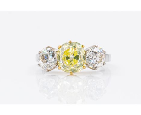 A YELLOW AND WHITE DIAMOND THREE STONE RINGFeaturing a central old mine cut, fancy light yellow diamond (estimated weight 2.3