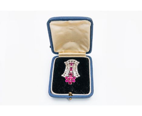 AN ART DECO RUBY AND DIAMOND CLIPSet with round and baguette cut diamonds, in a rub over setting, and cabochon, oval and bagu
