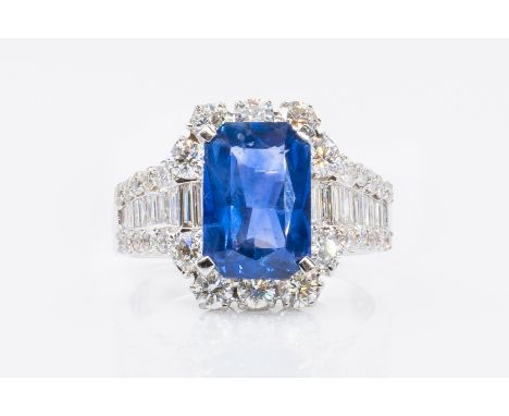 A SAPPHIRE AND DIAMOND DRESS RINGFeaturing a central step-cut blue sapphire (weight 3.55 carats) surrounded by baguette and r