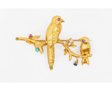 A GEMSET GOLD BIRD BROOCHFeaturing two birds each with a ruby eye sat on a branch featuring a single small diamond, sapphire,