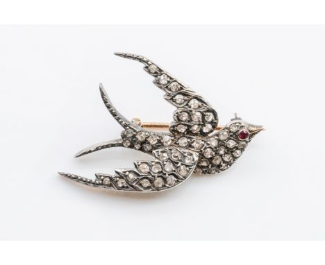 A VICTORIAN DIAMOND SWALLOW BROOCHDesigned as a swallow in flight, mounted with old cut and rose cut diamonds and with a ruby