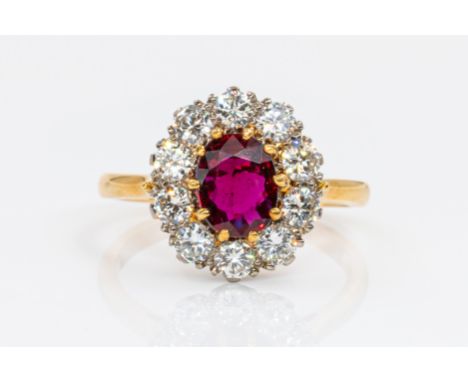 A RUBY AND DIAMOND CLUSTER RINGFeaturing a central oval ruby (weight 1.15 carats) in a claw setting, surrounded by ten round 