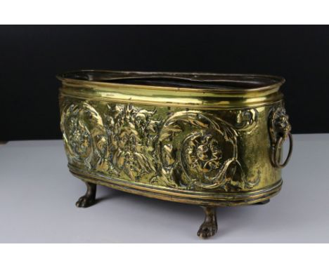 Arts and Crafts Brass Planter with embossed Green Man and Floral decoration, twin Lion Mask Ringed Handles and raised on four